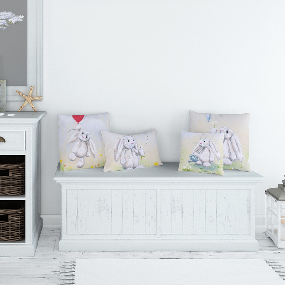 Adorable rabbit throw cushions on a white seating bench