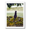 Black cat overlooking a misty landscape art print in a white frame. Portrait orientation