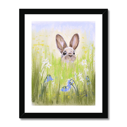 Rabbit in the meadow flowers fine art print with a white border in a black frame.