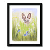 Rabbit in the meadow flowers fine art print with a white border in a black frame.