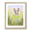 Rabbit in the meadow flowers fine art print with a white border in a natural light wooden frame.