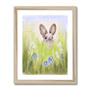 Rabbit in the meadow flowers fine art print with a white border in a natural light wooden frame.