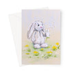 Adorable white rabbit blowing dandelion seeds, artwork greeting card. Portrait format