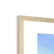 Fine art print with white border in a natural light wooden frame. Top corner detail